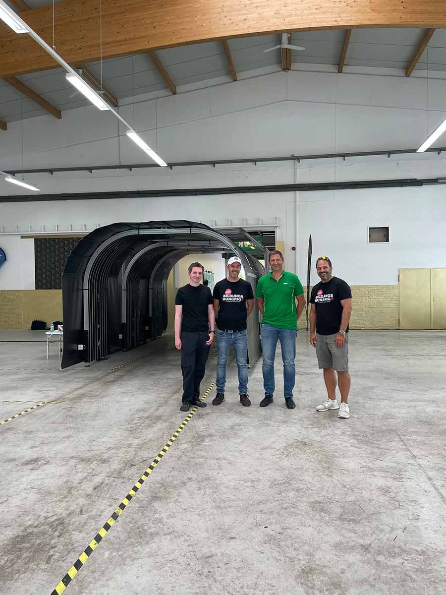 Daniel Siebrecht, Entwickler bei CombiSystems, Stefan Grimm, CombiChef bei Combi-Connect, Daniel Grass, Leitung Kfz-Sachverständige bei der DEVK Versicherung, Stefan Grimm, CombiChef bei CombiPlus vor dem Hagelscanner in der Halle von der PDR-Team GmbH.